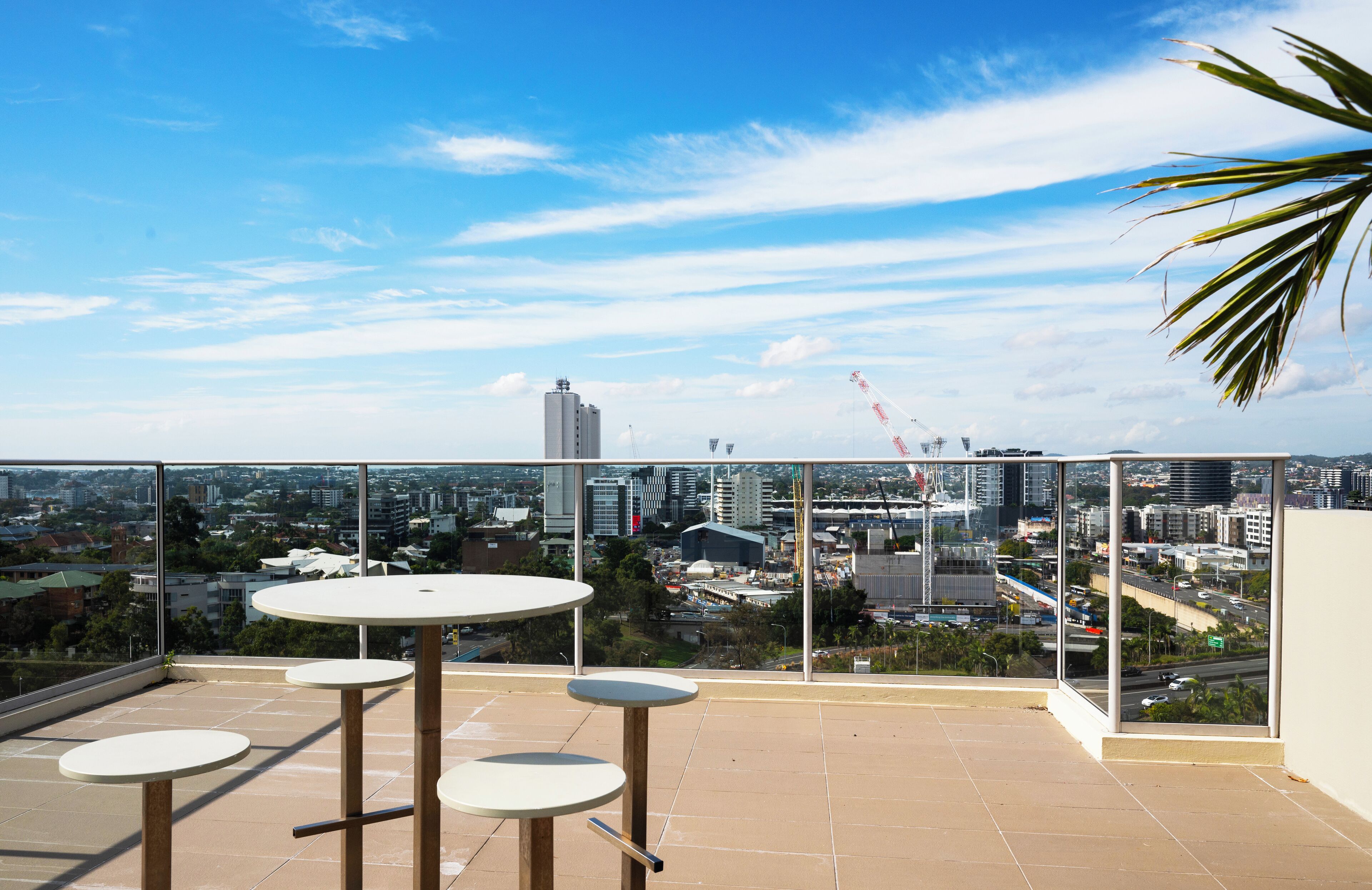 A balcony with a city view, featuring a table and chairs.