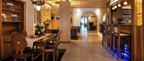 Ein Holzinterieur mit Essbereich, Bar und Steinwand.