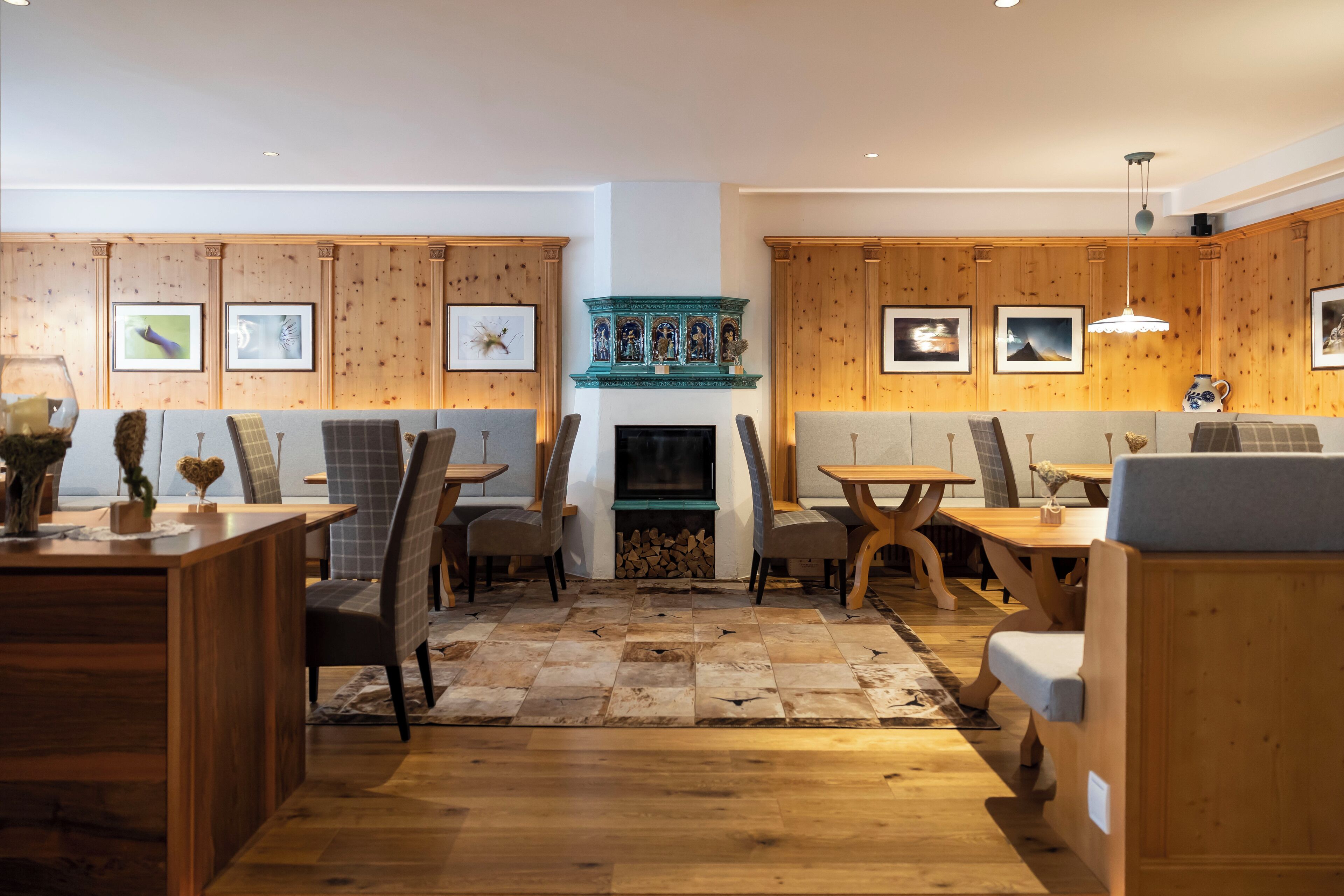 A cozy living room with wooden panel walls, a fireplace, and a dining area with wooden furniture.