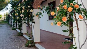 Uma fileira de edifícios brancos com telhados de tijolo, cada um com uma pequena janela e porta.