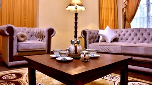 Un salon avec deux canapés, une table basse et une lampe.