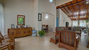 A spacious living area with a wooden cabinet, a dining table, and a sofa. - Hanthana Holiday Rooms (Kandy)
