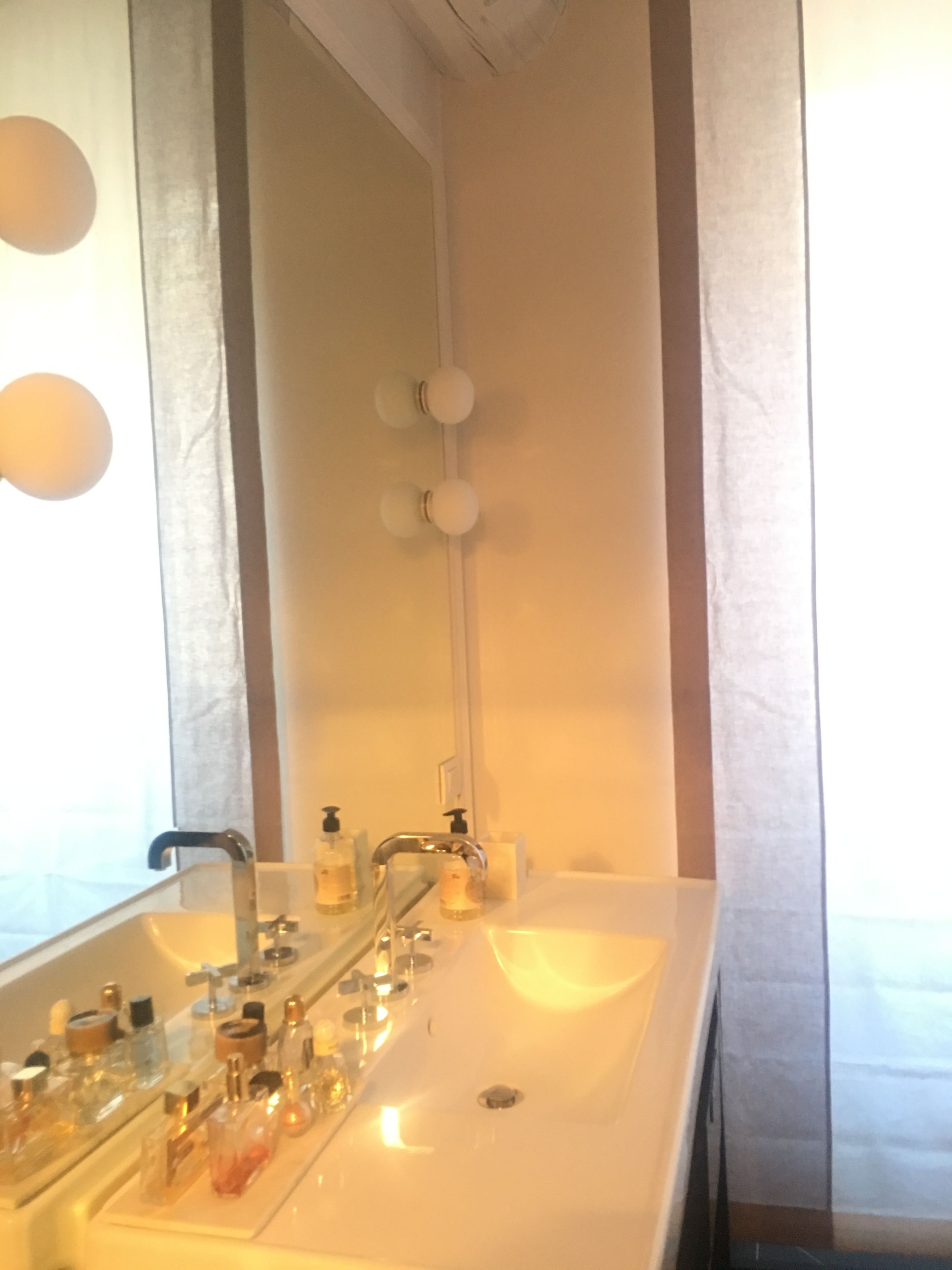 Un baño con un espejo grande, dos lavamanos y una ducha.
