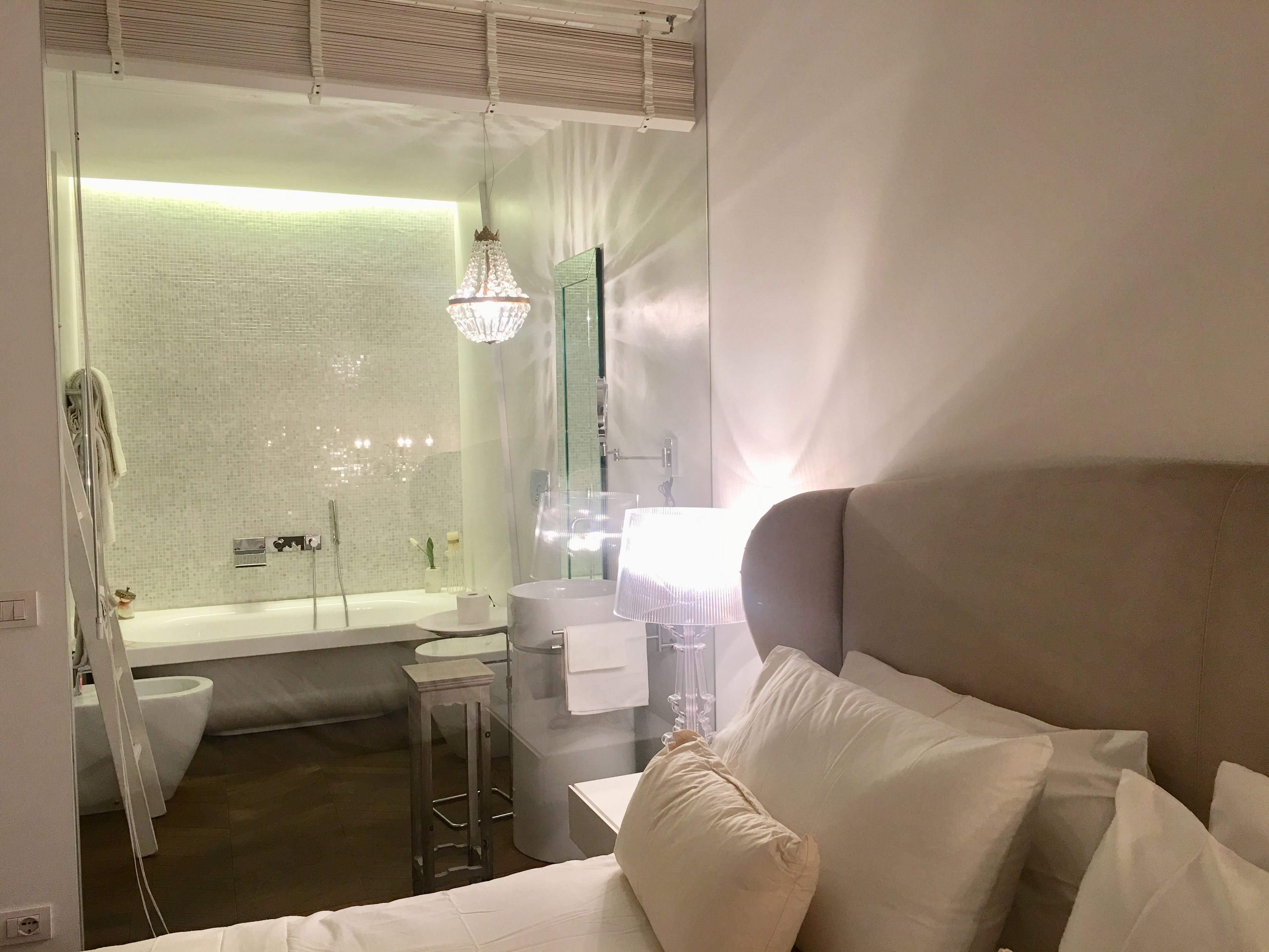 A modern bathroom with a bathtub, a shower, and a toilet. There is a vanity with a mirror and a towel rack.