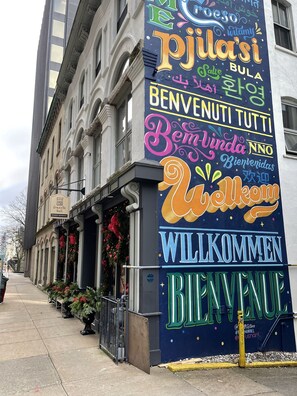 A building with a colorful sign featuring multiple languages welcoming visitors. - Granville Hall Residence (Halifax)