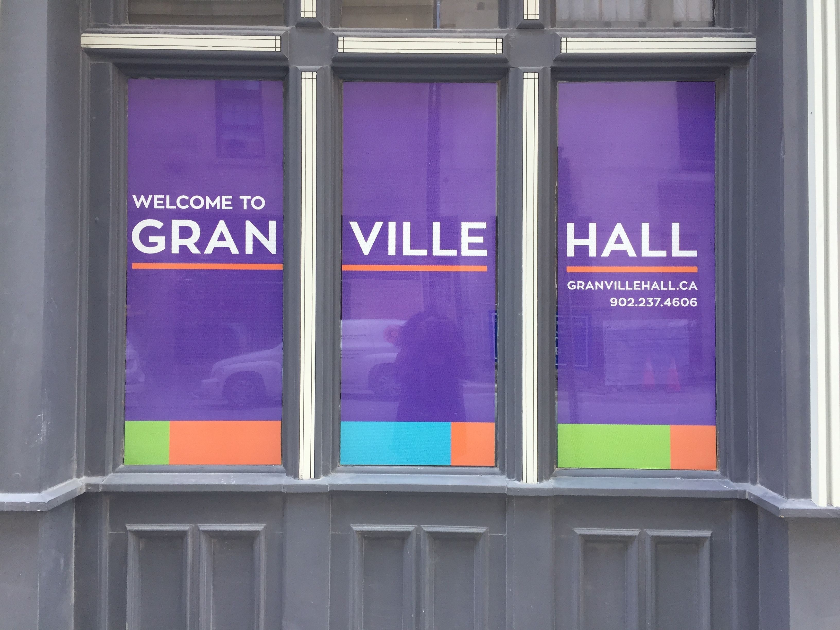 A window with three purple panels displaying "WELCOME TO GRANVILLE HALL" and a phone number.