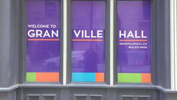 A window with three purple panels displaying "WELCOME TO GRANVILLE HALL" and a phone number.