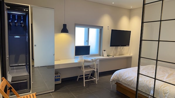 A bedroom with a bed, a desk with a computer, a chair, a window, and a TV on the wall. - Hotel The Spot (Gwangju)