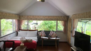A cozy room with a bed, a sofa, a small table, and a TV. - Jilufugan B&B (Jinfeng)