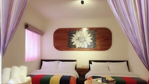 A cozy room with two beds, a wooden table, and a decorative wall piece. - Jilufugan B&B (Jinfeng)