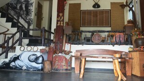 A rustic interior with a wooden staircase, a traditional fan, and various cultural artifacts. - Jilufugan B&B (Jinfeng)