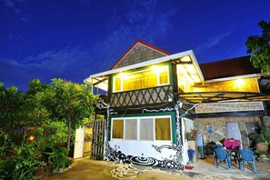 A two-story house with a balcony, surrounded by lush greenery. - Jilufugan B&B (Jinfeng)