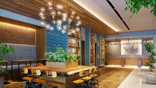 A modern interior with a wooden dining area, bookshelves, and a decorative light fixture. - Mitsui Garden Hotel Otemachi Tokyo  (Tokyo)