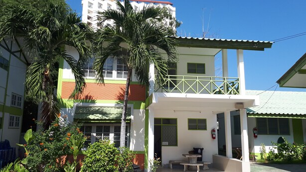 A two-story building with a balcony, potted plants, and a fire extinguisher. - Sukhothai Bungalow (Cha-am)
