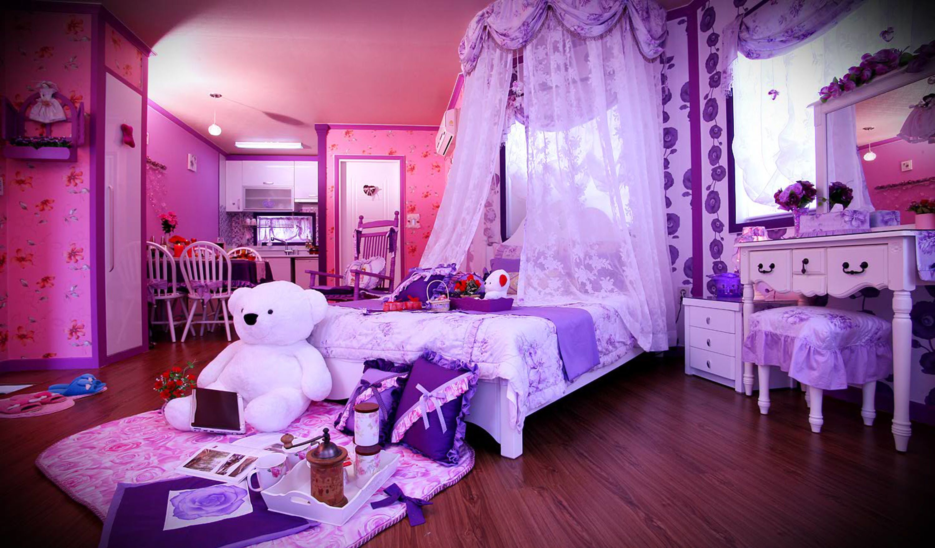 Une chambre à coucher décorée dans des tons roses, avec un lit, une commode, une chaise et un bureau.