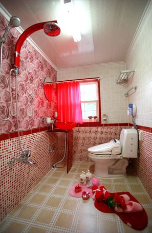 Une salle de bain avec un lavabo rouge, des toilettes et une douche.