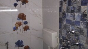 A bathroom with a toilet, a shower, and a sink. - M S Hotel (Bhagalpur)