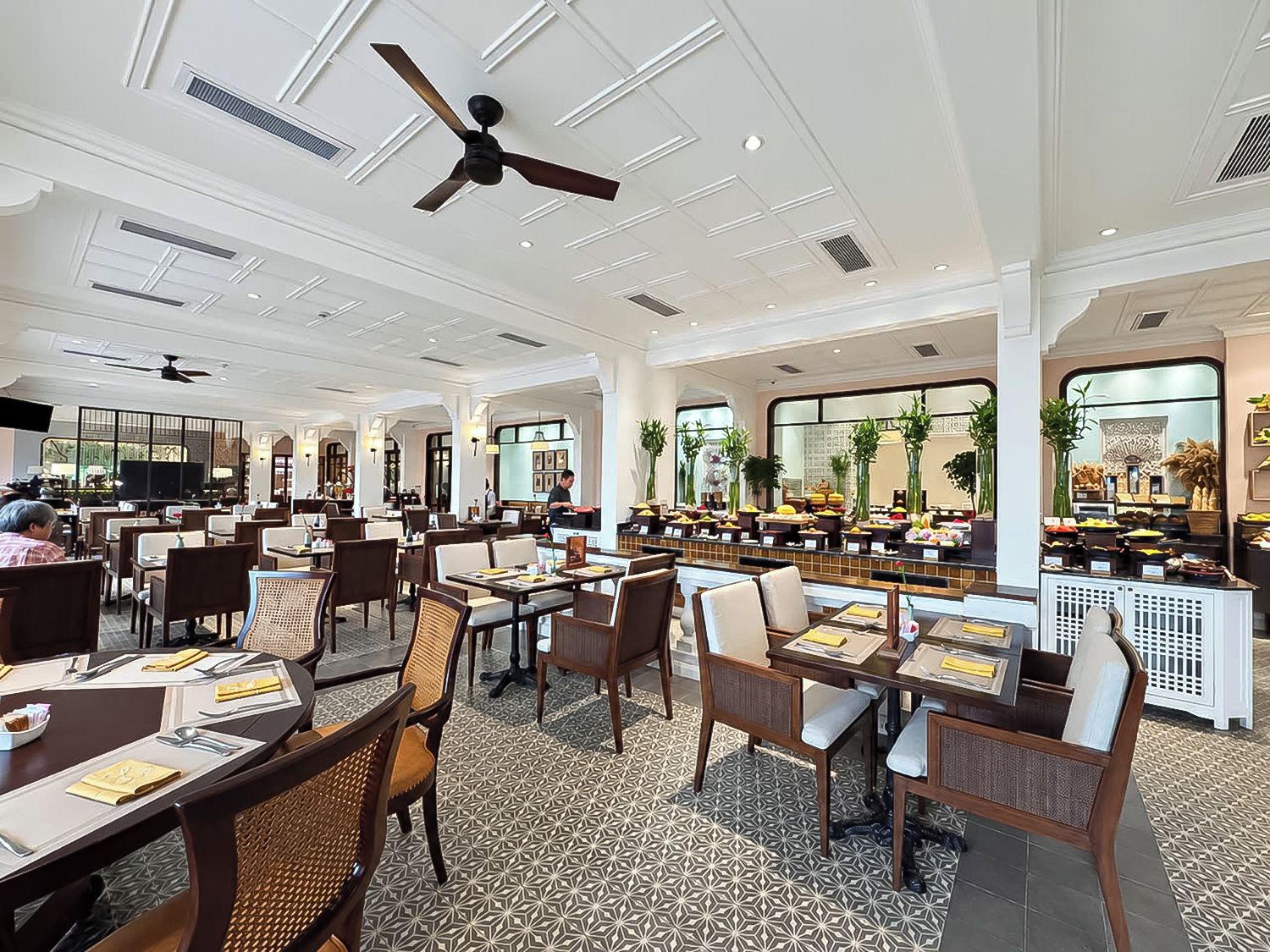 A spacious restaurant with high ceilings, multiple dining tables, and a variety of seating options.