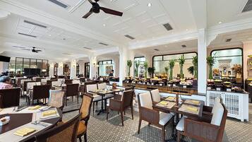 A spacious restaurant with high ceilings, multiple dining tables, and a variety of seating options.