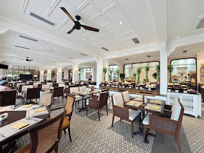 Ein geräumiges Restaurant mit hohen Decken, mehreren Tischen und unterschiedlichen Sitzgelegenheiten.