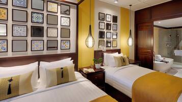 Une chambre d’hôtel avec deux lits, une table de chevet avec une horloge et une plante, et une salle de bain avec une douche et un lavabo.