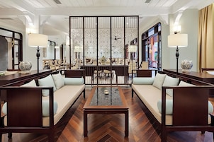 A spacious lounge area with a central coffee table, sofas, and a decorative partition.