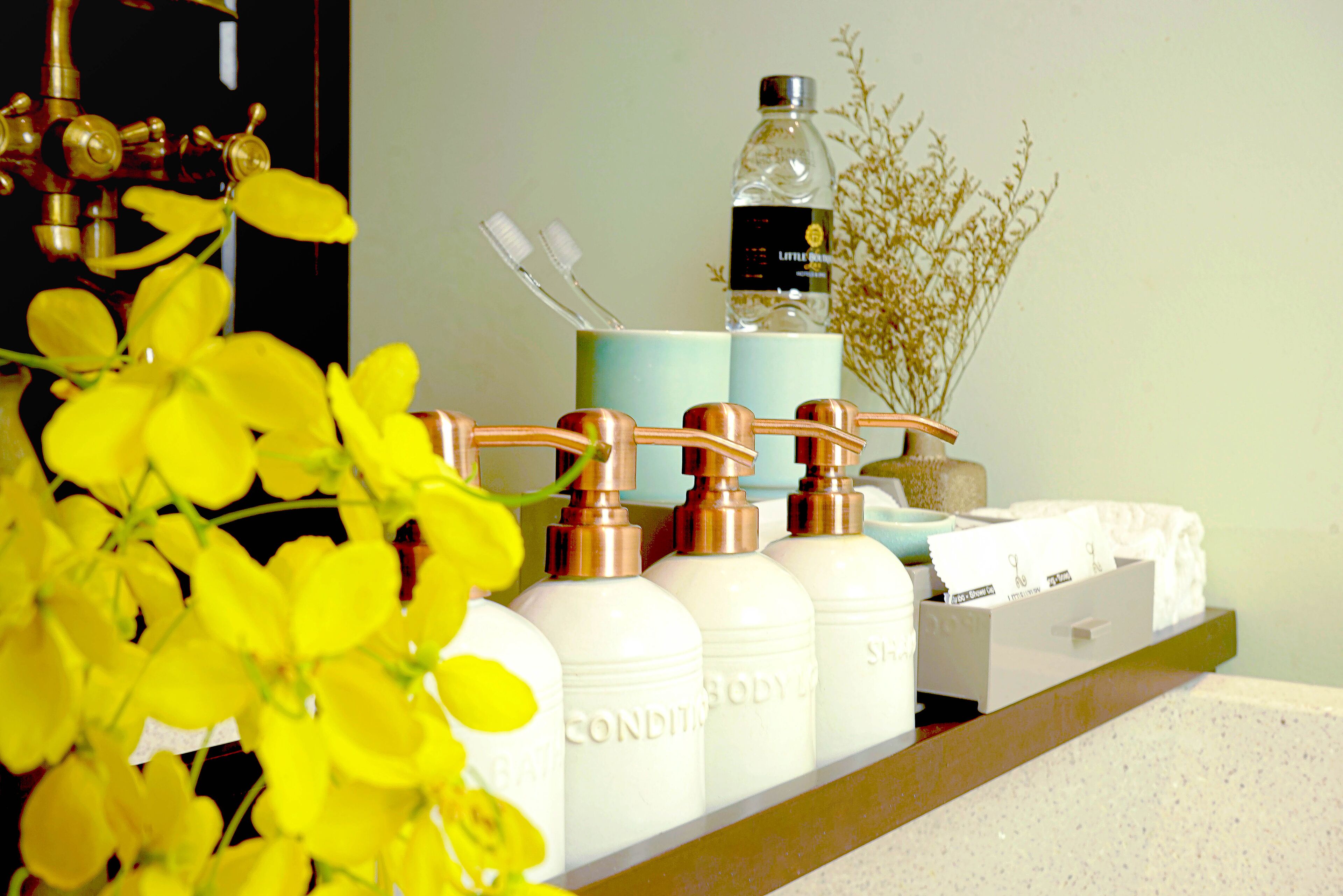 A bathroom shelf with toiletries including bottles labeled "BODY" and a bottle of water.