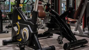 A gym with exercise equipment, including an elliptical and a stationary bike.