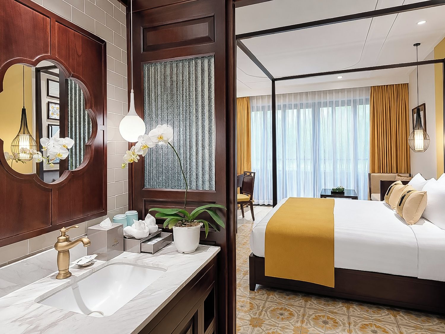 Habitación de hotel con una cama grande, un baño con lavamanos y espejo, y vistas a la ciudad.