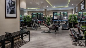 Un gimnasio con diferentes equipos de ejercicio, una banca y una cinta de correr.