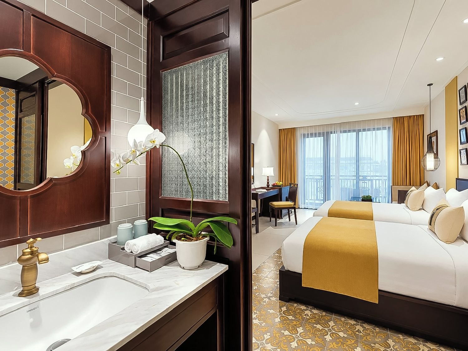 Una habitación de hotel con una cama grande, un escritorio y un baño con espejo y lavamanos.