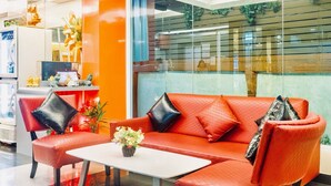 A modern lobby with a red leather sofa, a white coffee table, and a small plant. - The Konnect Hotel (Bangkok)