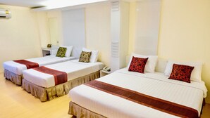 A hotel room with three single beds, each with a red and white bedspread and matching pillows. - The Konnect Hotel (Bangkok)
