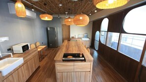 A modern kitchen with a central island, wooden cabinets, and pendant lighting. - Green Inn Kaohsiung (Kaohsiung)