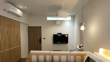 Habitación doble Deluxe | Área de sala de estar | Televisión LCD