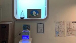 A room with a small window, a wall-mounted clock, a thermostat, and a map on the wall. - Green Inn Kaohsiung (Kaohsiung)