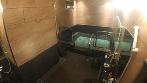 Uma casa de banho moderna com banheira de hidromassagem envidraçada, zona de duche e sanita.
