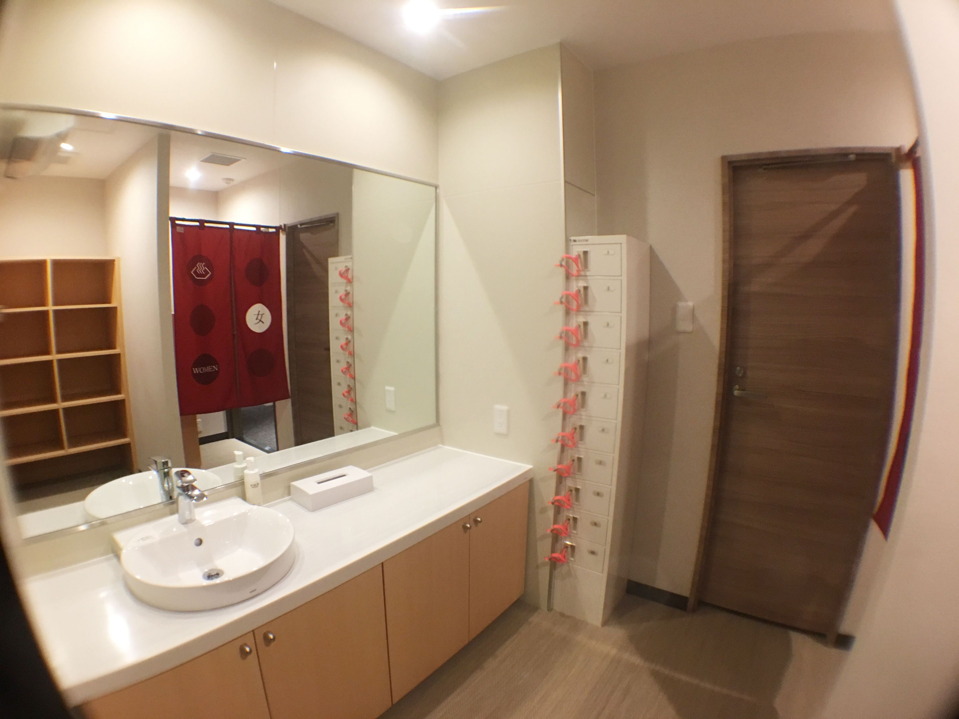 A bathroom with a sink, mirror, and storage cabinets.