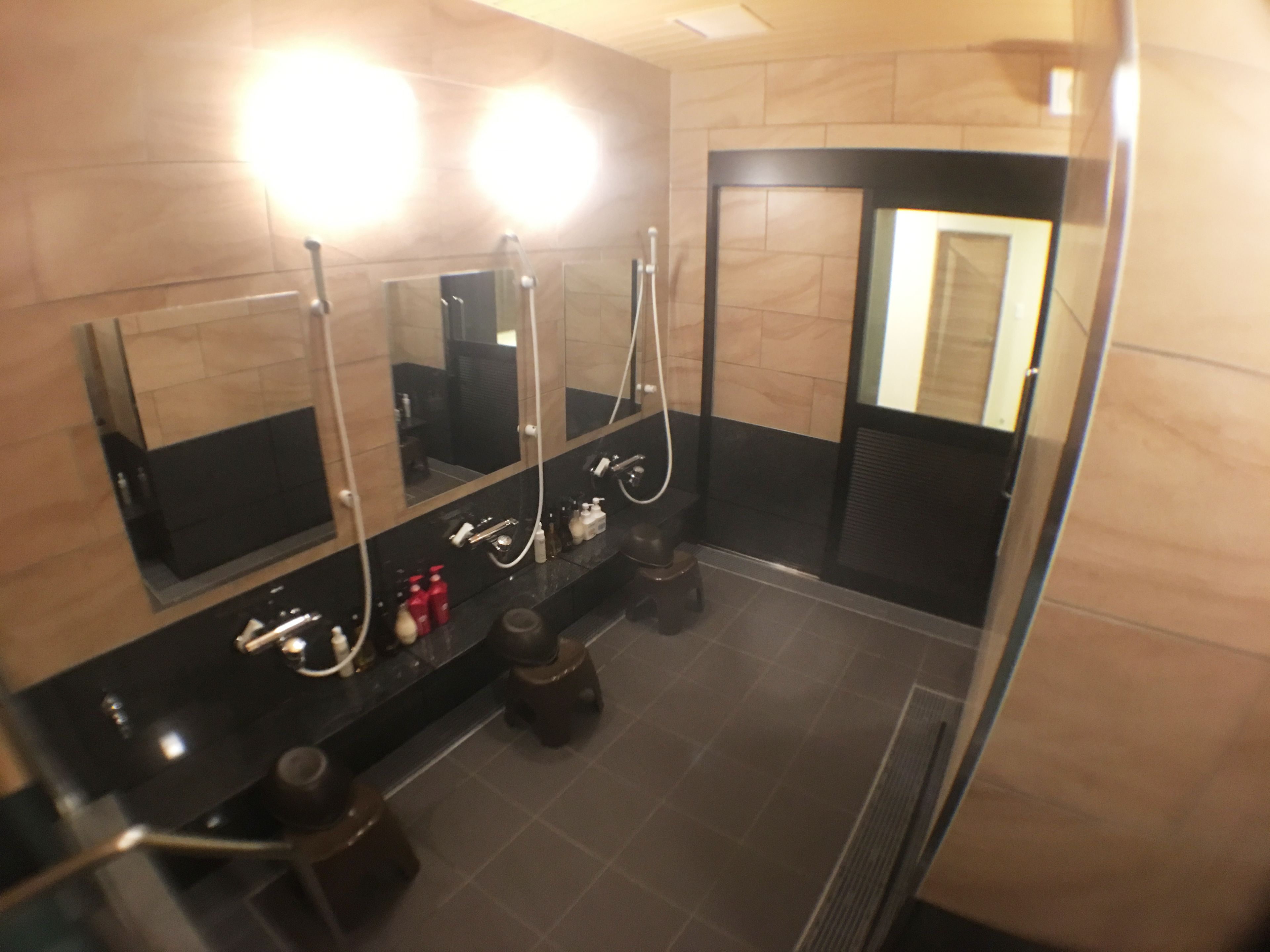 Un baño moderno con dos lavamanos, espejos y suelo con calefacción.