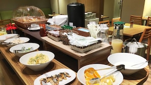 Disposição de buffet com diversos alimentos e utensílios.