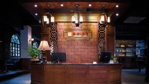 A reception desk with a sign reading "Memory Inn," surrounded by wooden paneling and decorative lighting fixtures. - Memory Inn Guilin Central (Guilin)