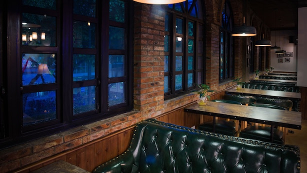 A restaurant with brick walls, large windows, and green leather booths. - Memory Inn Guilin Central (Guilin)
