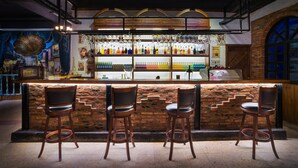A bar area with a brick wall, wooden bar counter, and three bar stools. - Memory Inn Guilin Central (Guilin)