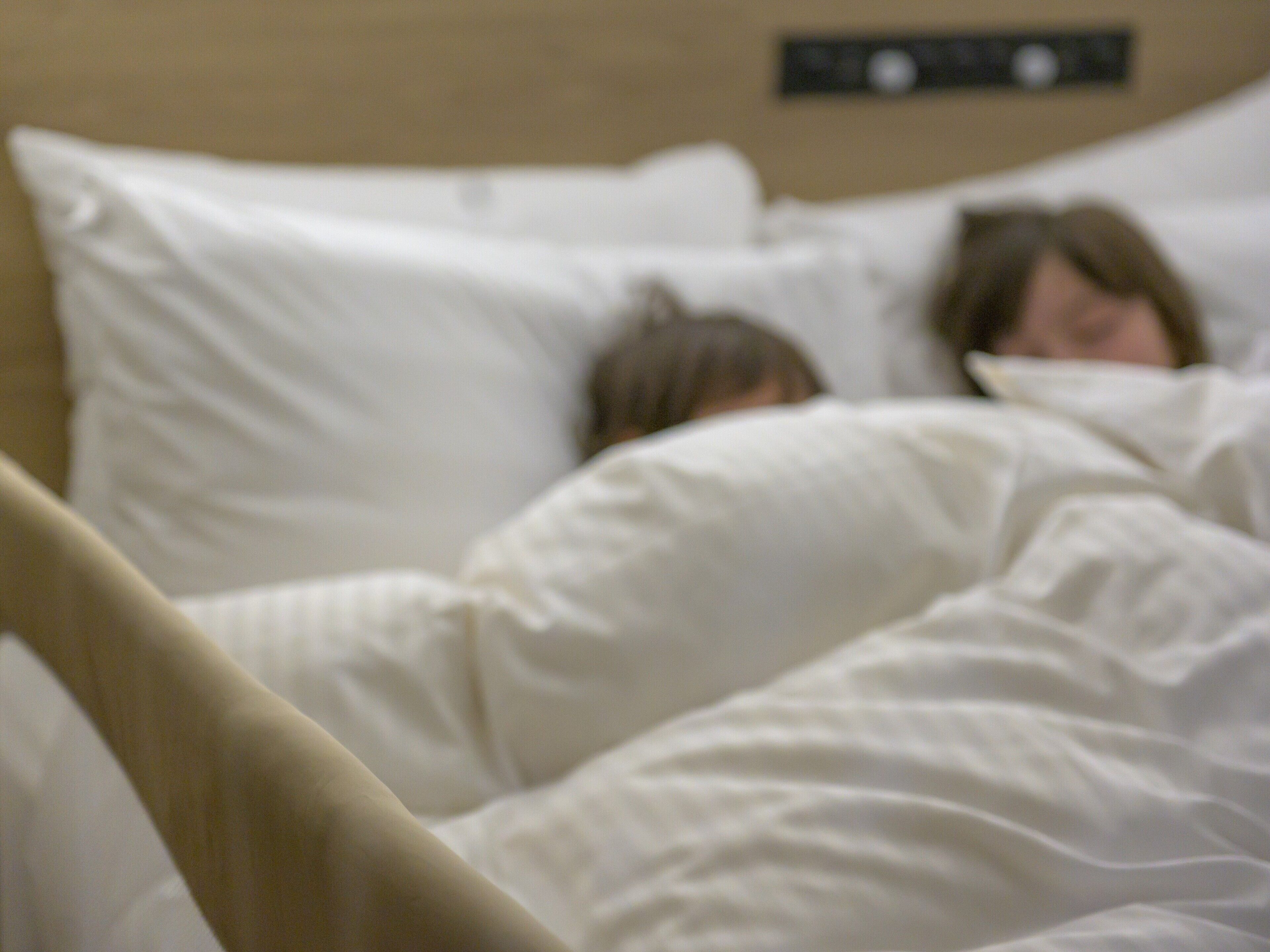 A bed with white bedding and a headboard.