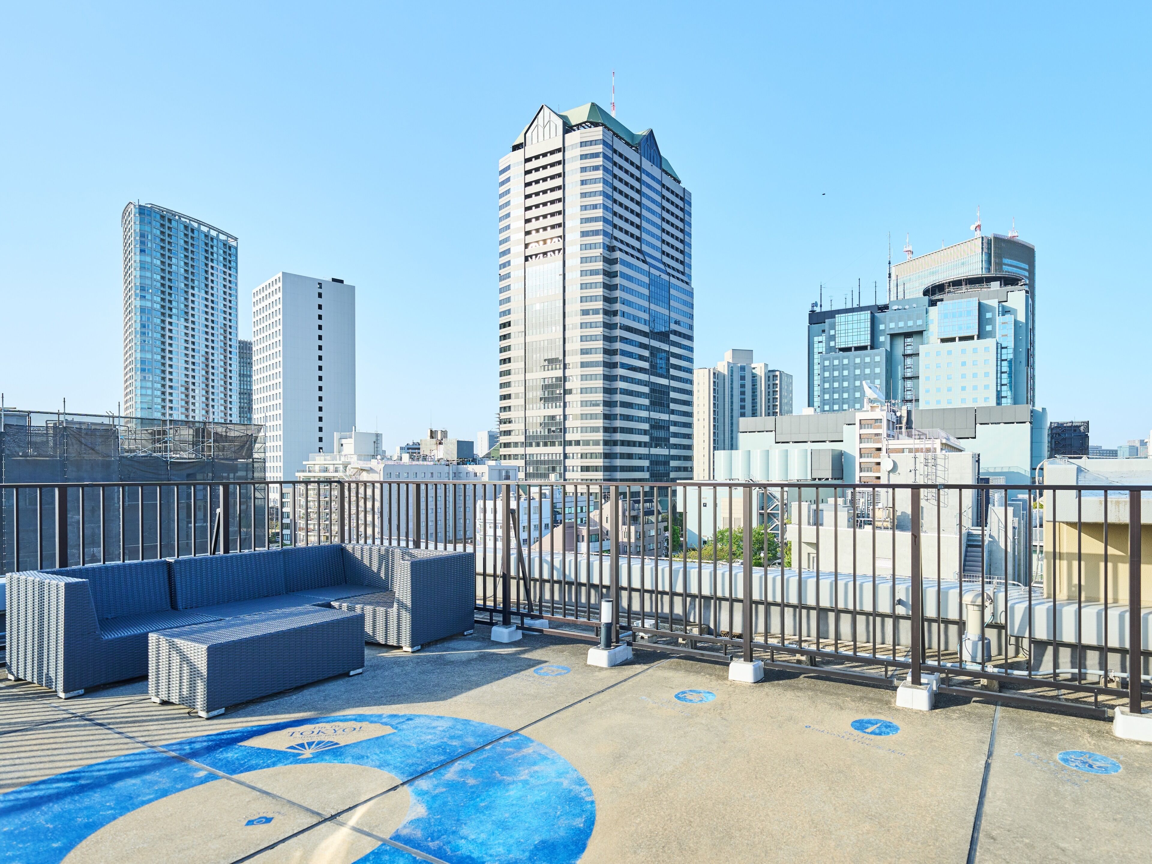 Terraza en la azotea con mobiliario y vista al horizonte de la ciudad.