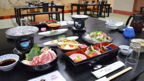 A dining table with various dishes and utensils, including bowls, plates, chopsticks, and a menu. - Yunominesou (Tanabe)
