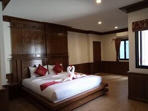 A bedroom with a large bed, wooden headboard, and a window with curtains. - Lanta White's House (Ko Lanta)