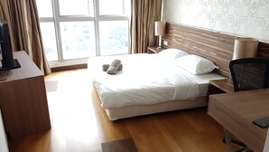 A hotel room with a bed, a desk, a chair, and a window with curtains. - Regalia Studio 109 Suites (Kuala Lumpur)