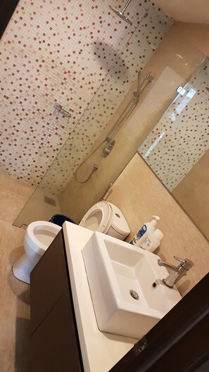 A bathroom with a toilet, sink, and shower. - Regalia Studio 109 Suites (Kuala Lumpur)