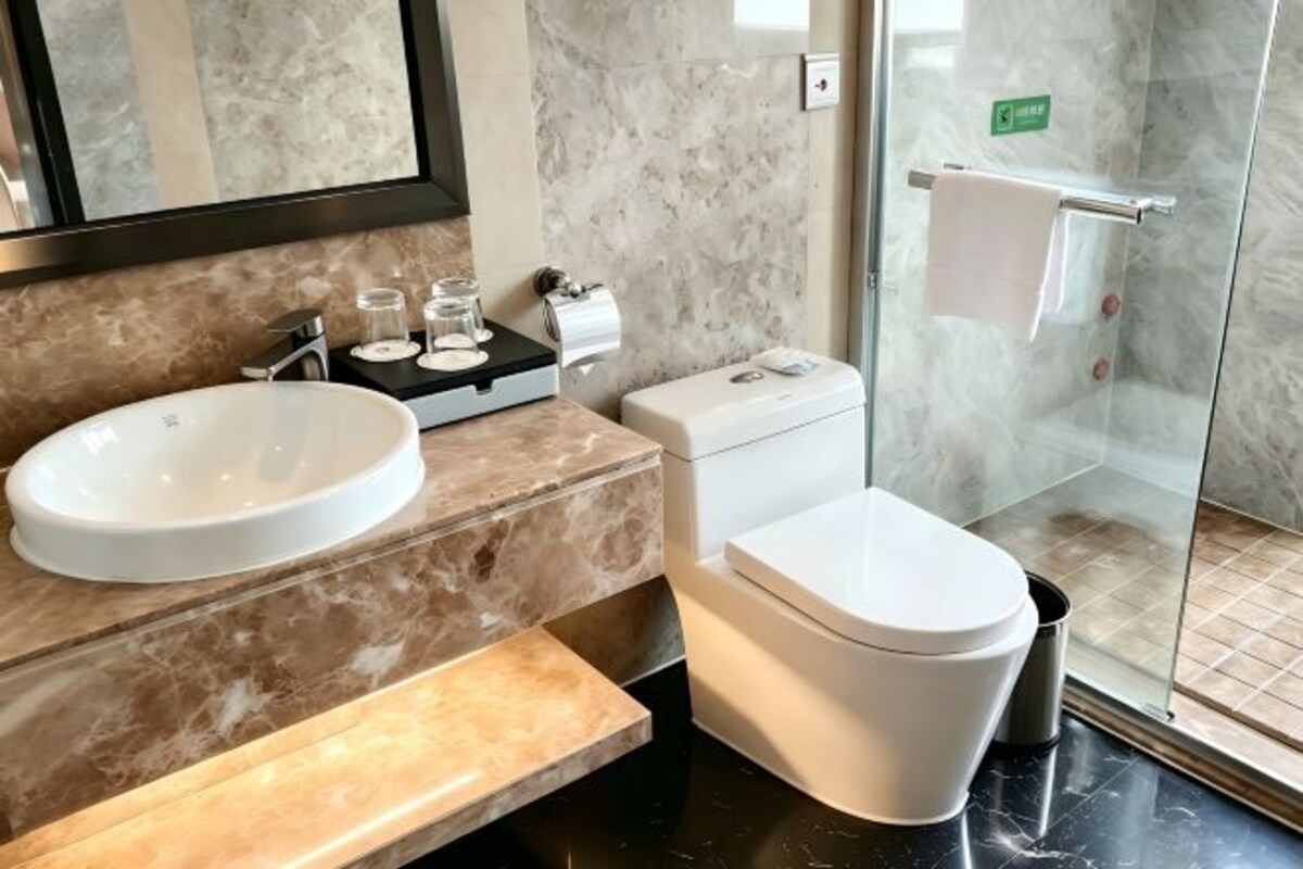 A bathroom with a sink, toilet, and glass-enclosed shower.